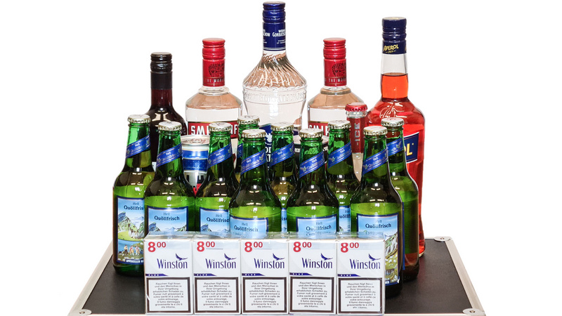 Farbige Alkoholflaschen und eine Stange Zigaretten